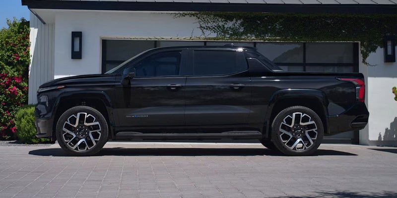 A Chevrolet Silverado EV parked in front of a residential house, showcasing its sleek design and modern features.